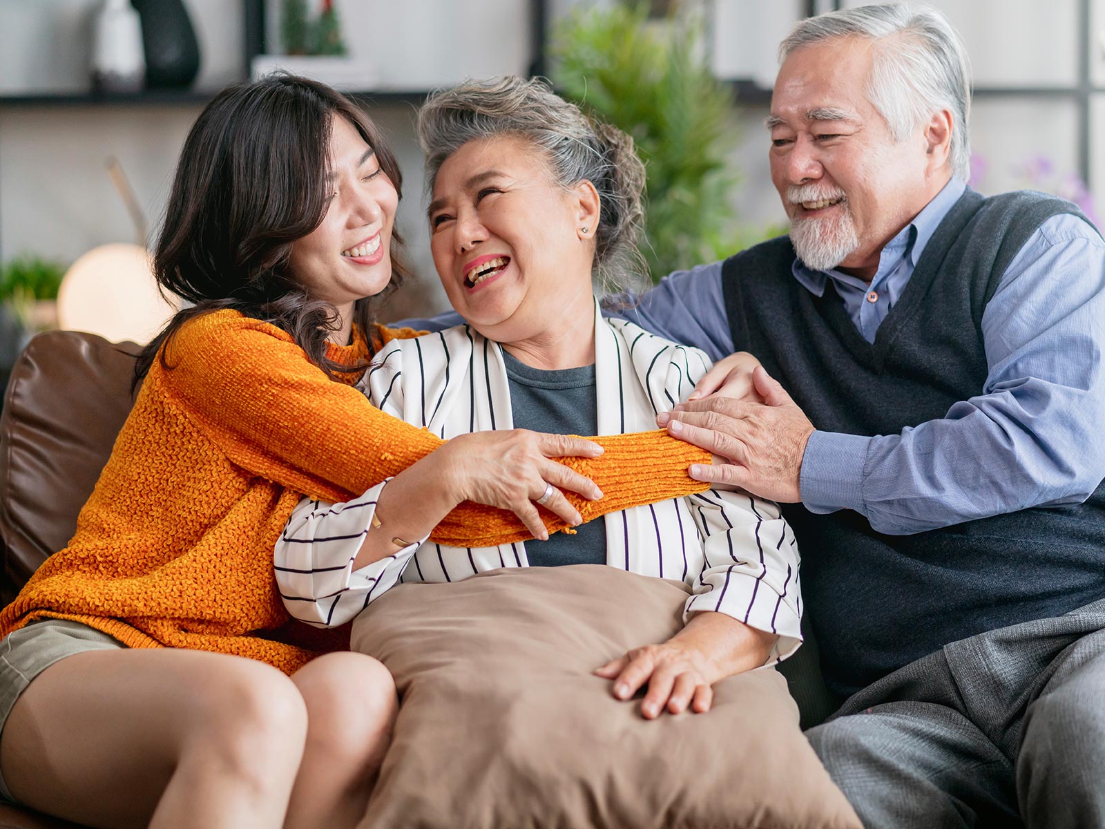 A granddaughter hugging her grandparents.