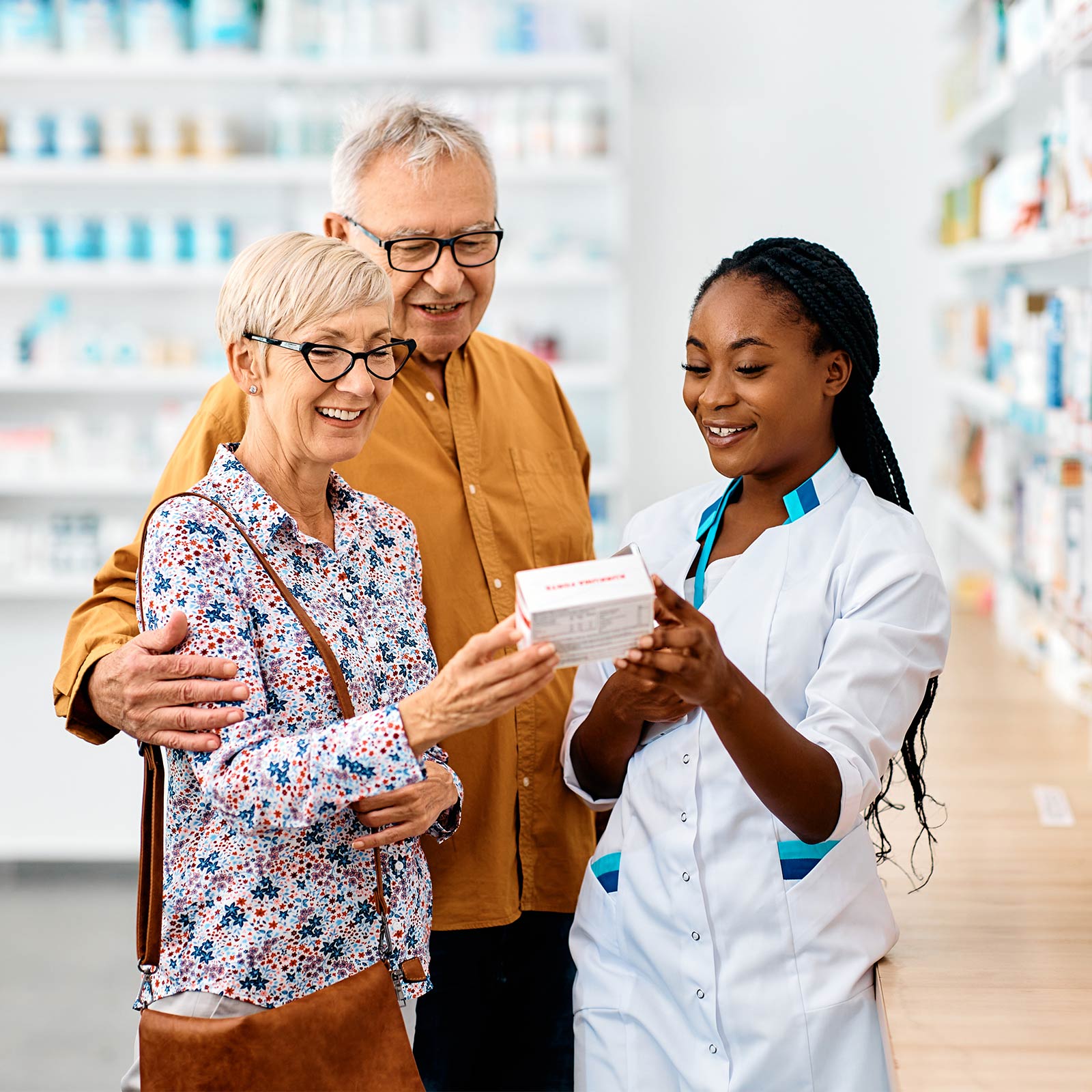 A pharmacist showing an older couple medicine.