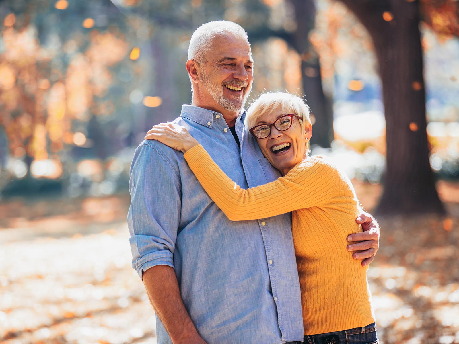 An older couple hugging and smiling outside