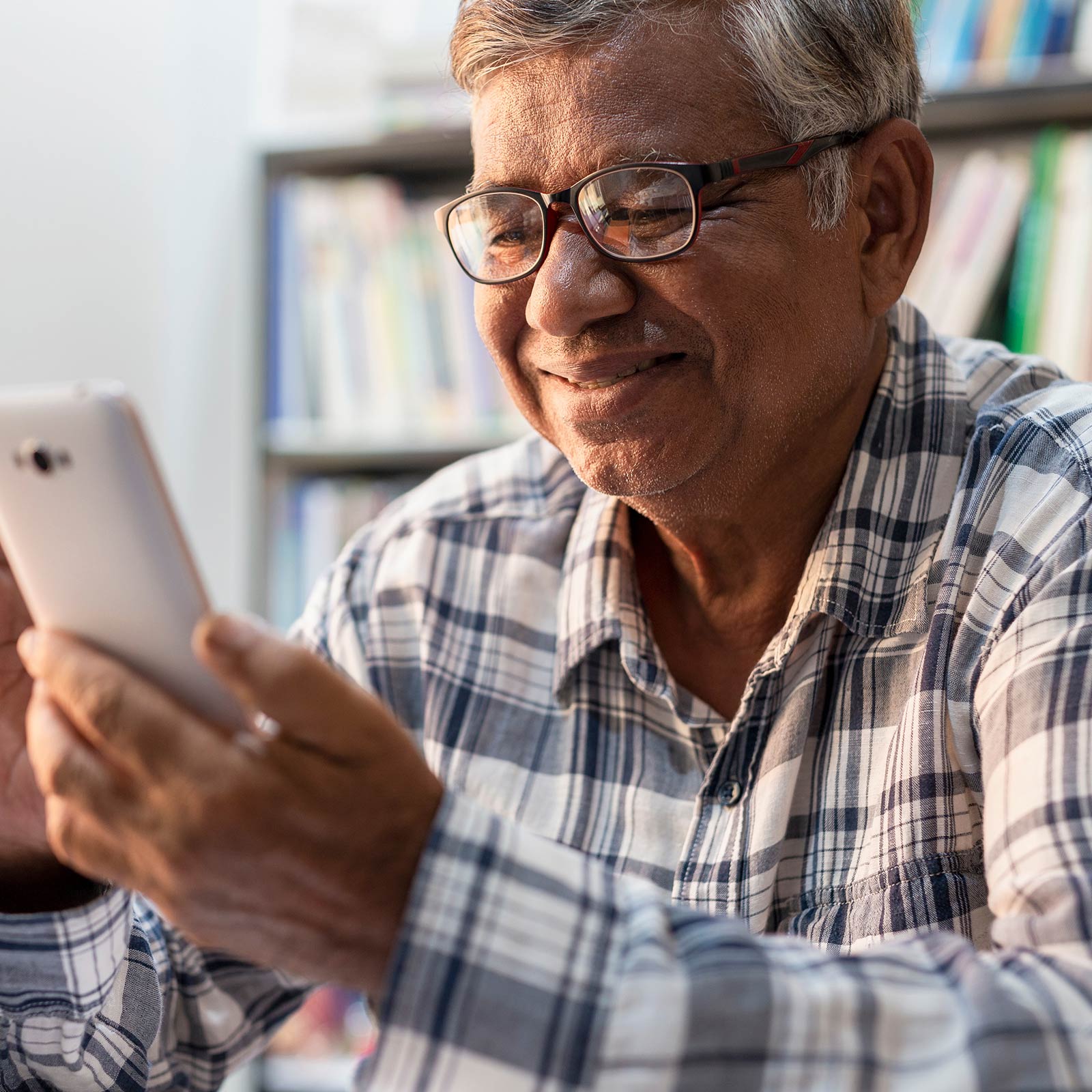 Man cheerfully uses smartphone