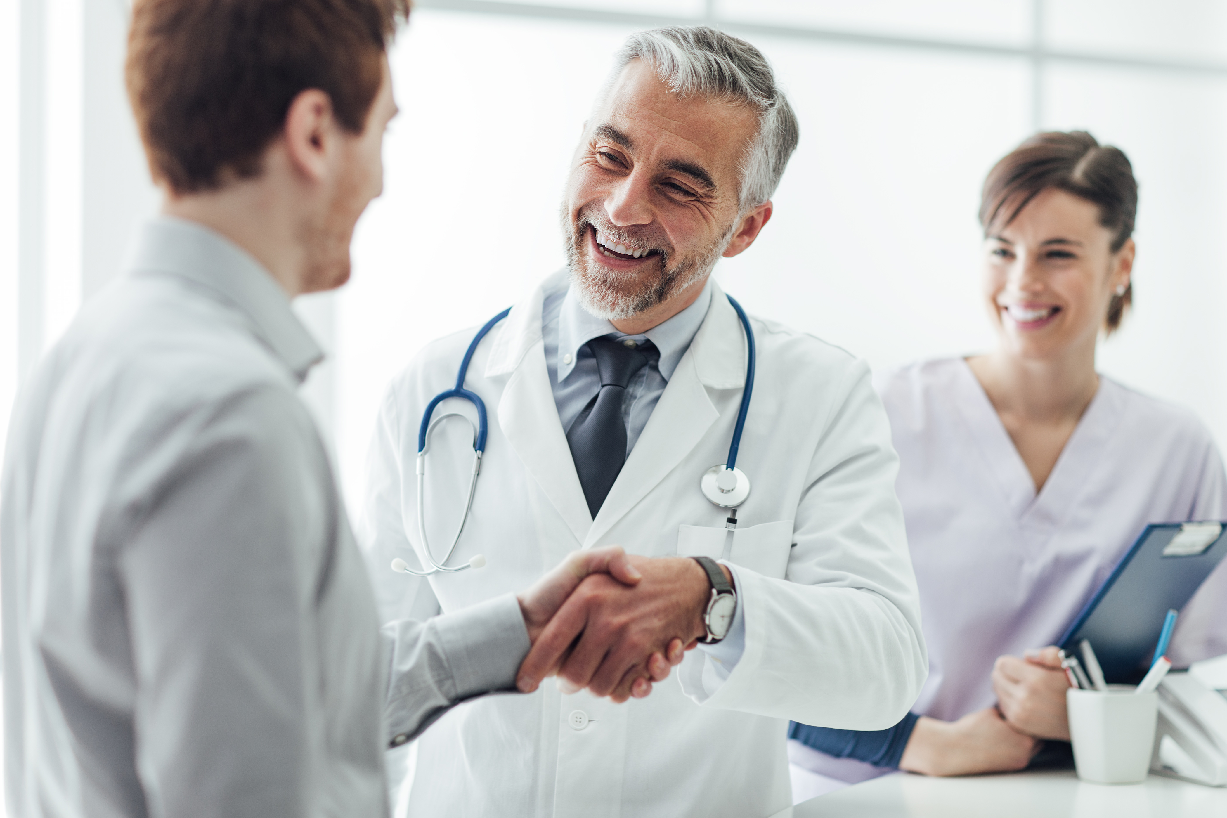 A doctor shaking hands with a man.