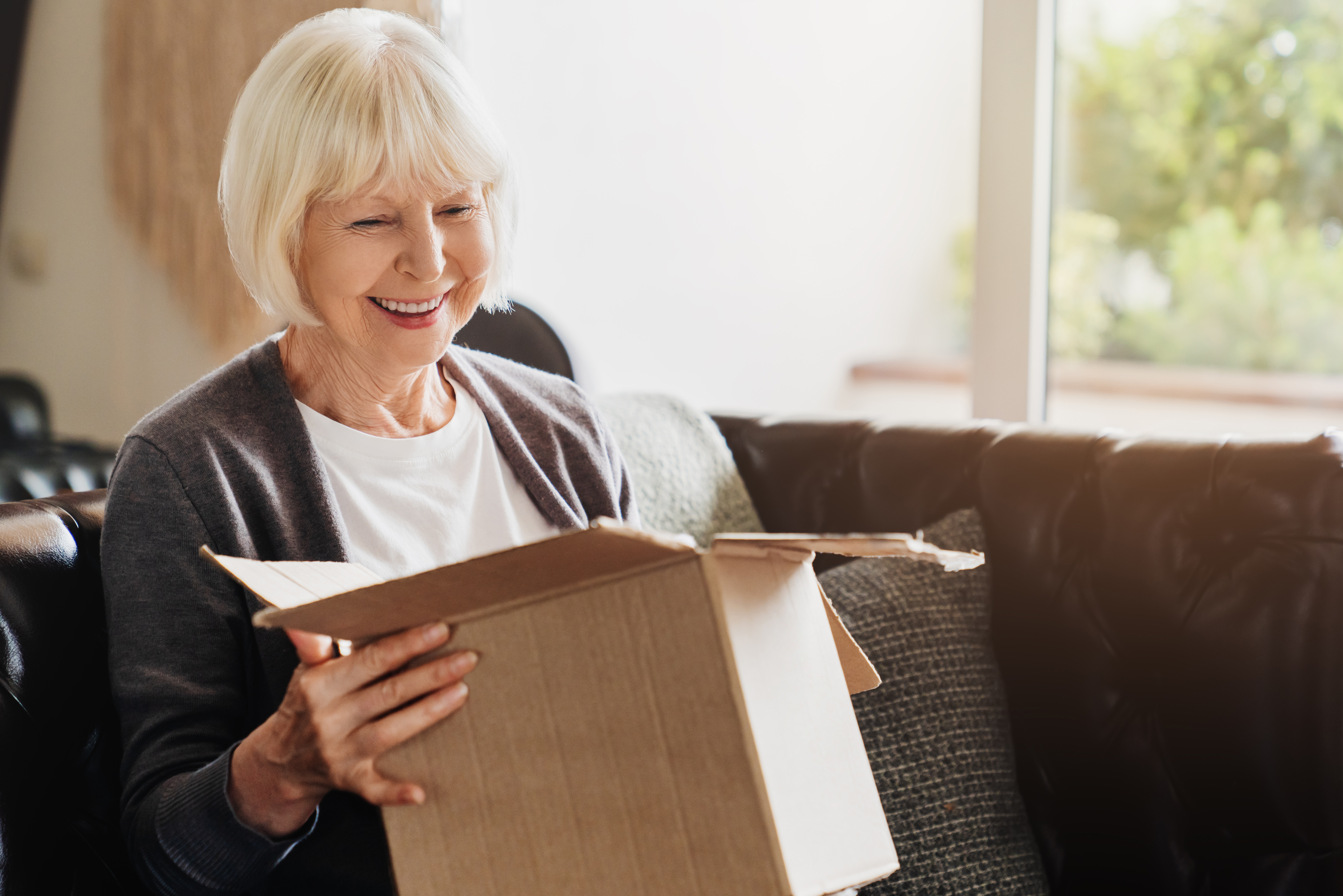 An older woman opening a package.