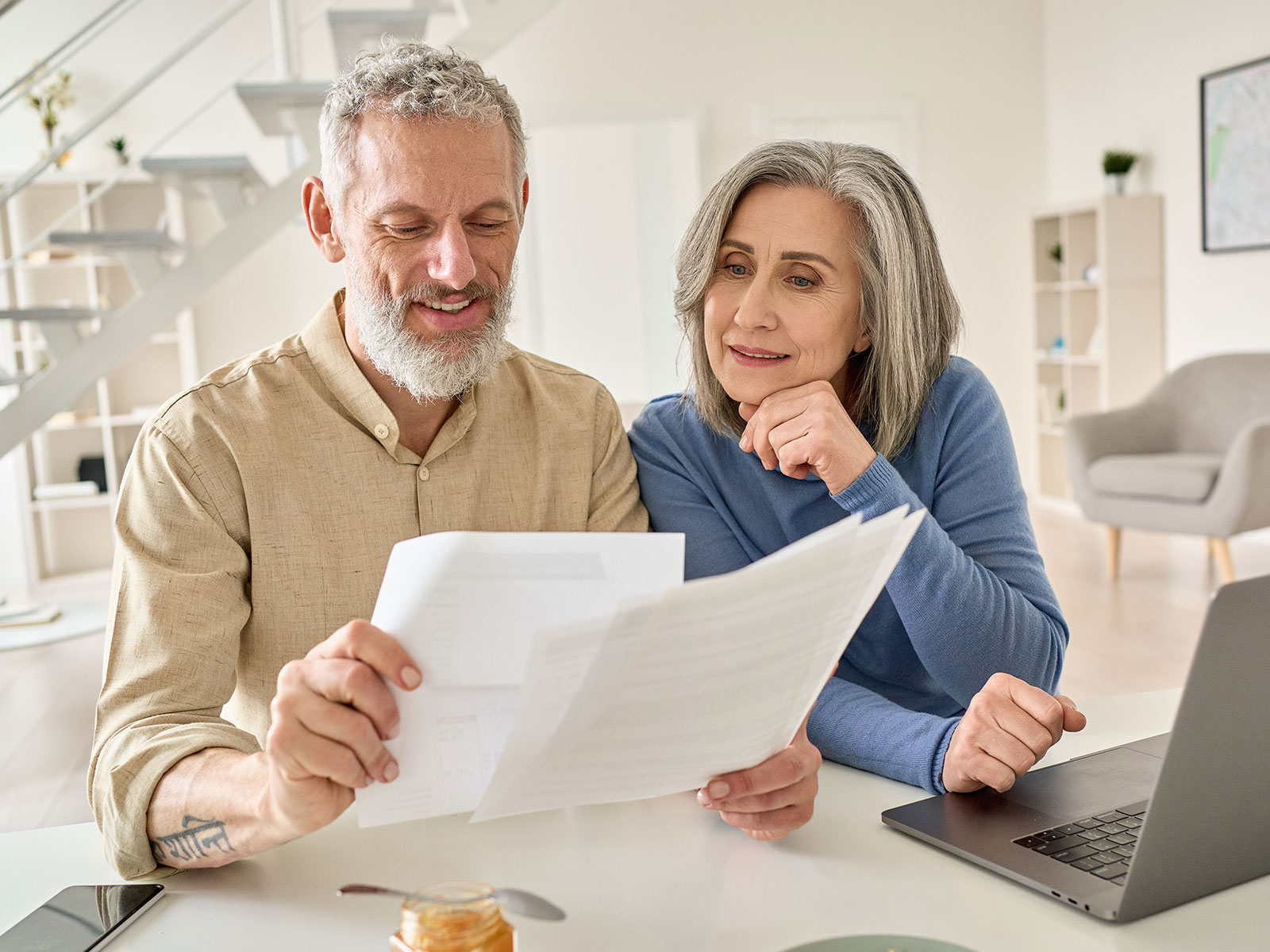 An older couple looking at a few sheets of paper.