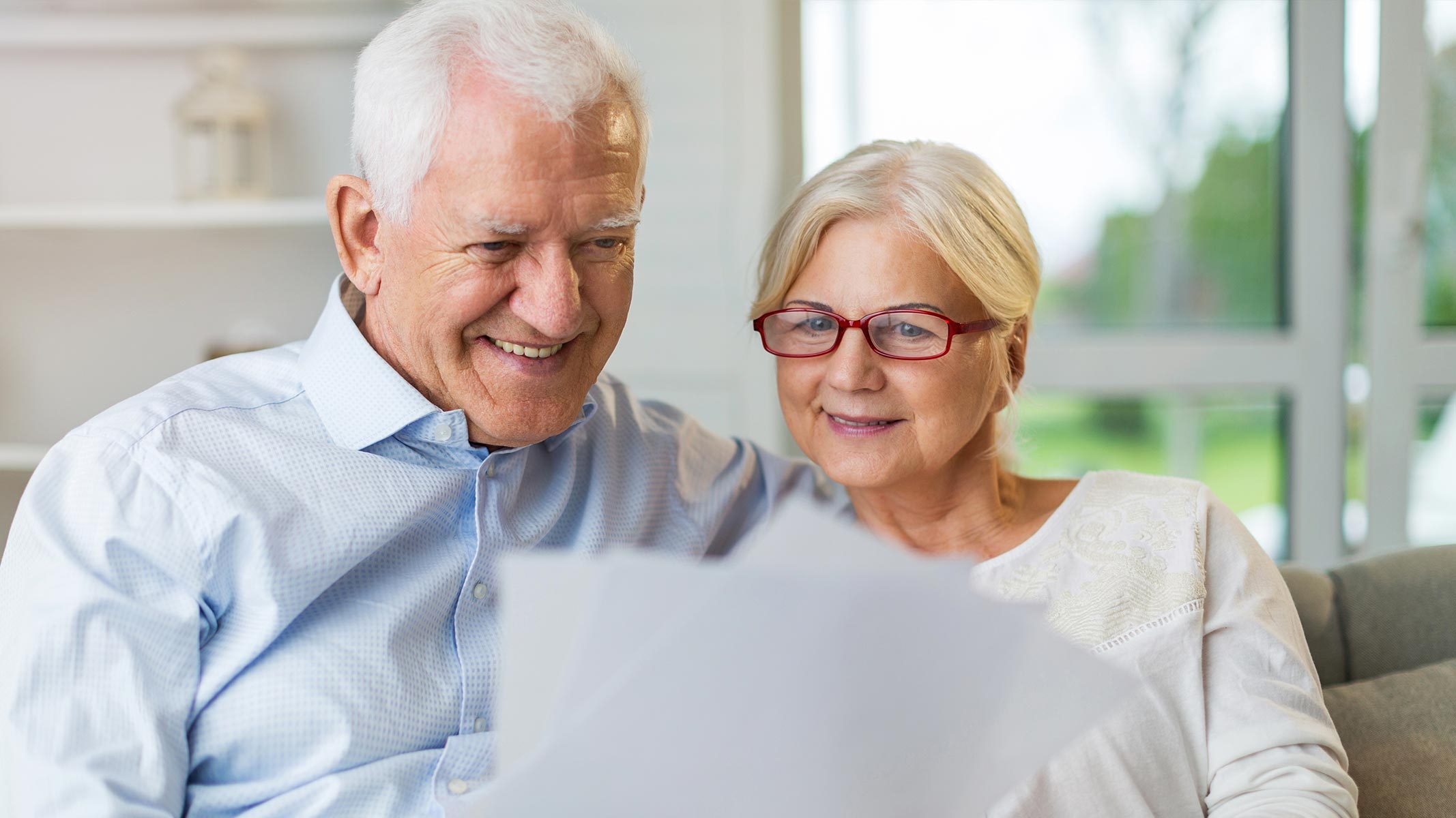 Couple considers insurance paperwork from comfort of their couch