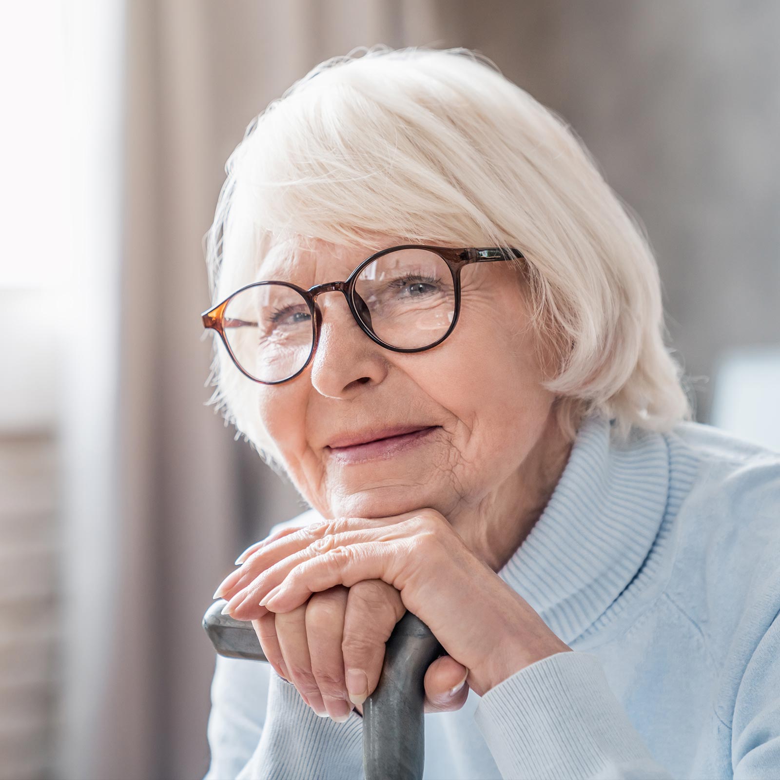 Woman relaxing chin on folded hands and smiling into camera