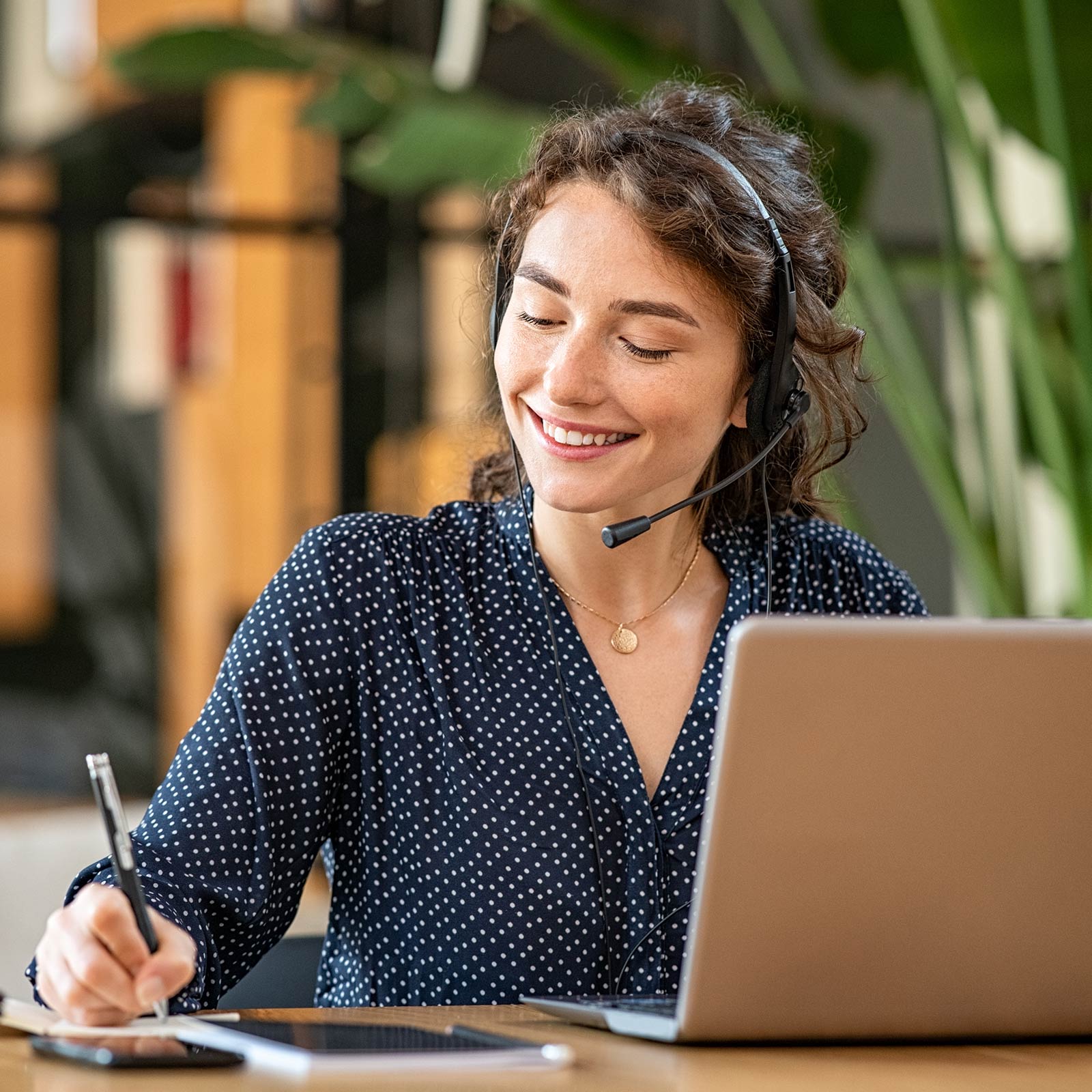 A customer representative smiling while writing