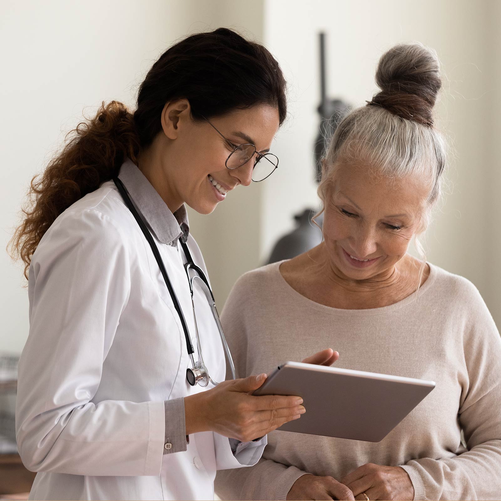 A healthcare provider showing a patient something on the tablet.
