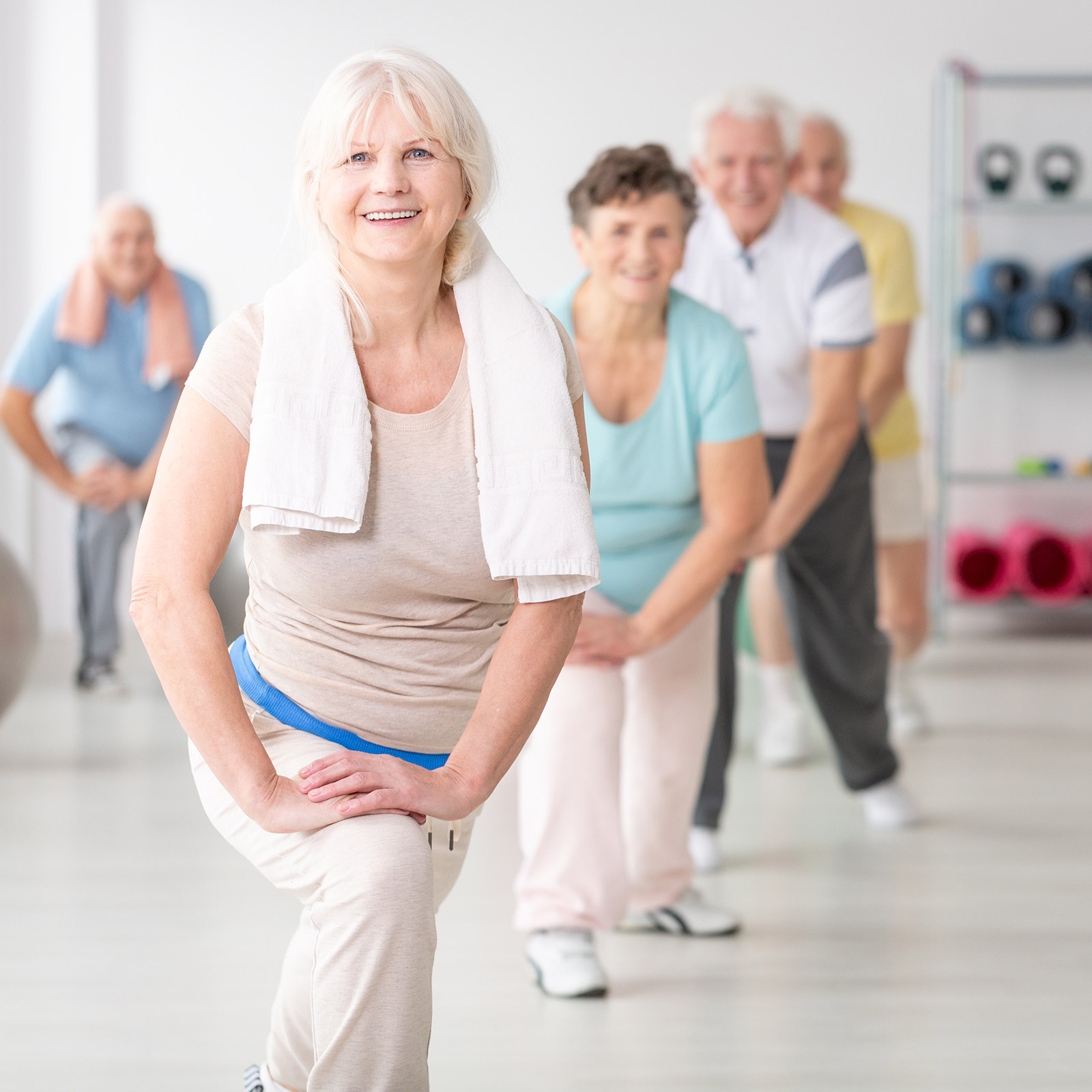 Group of older people in a yoga class and smiling