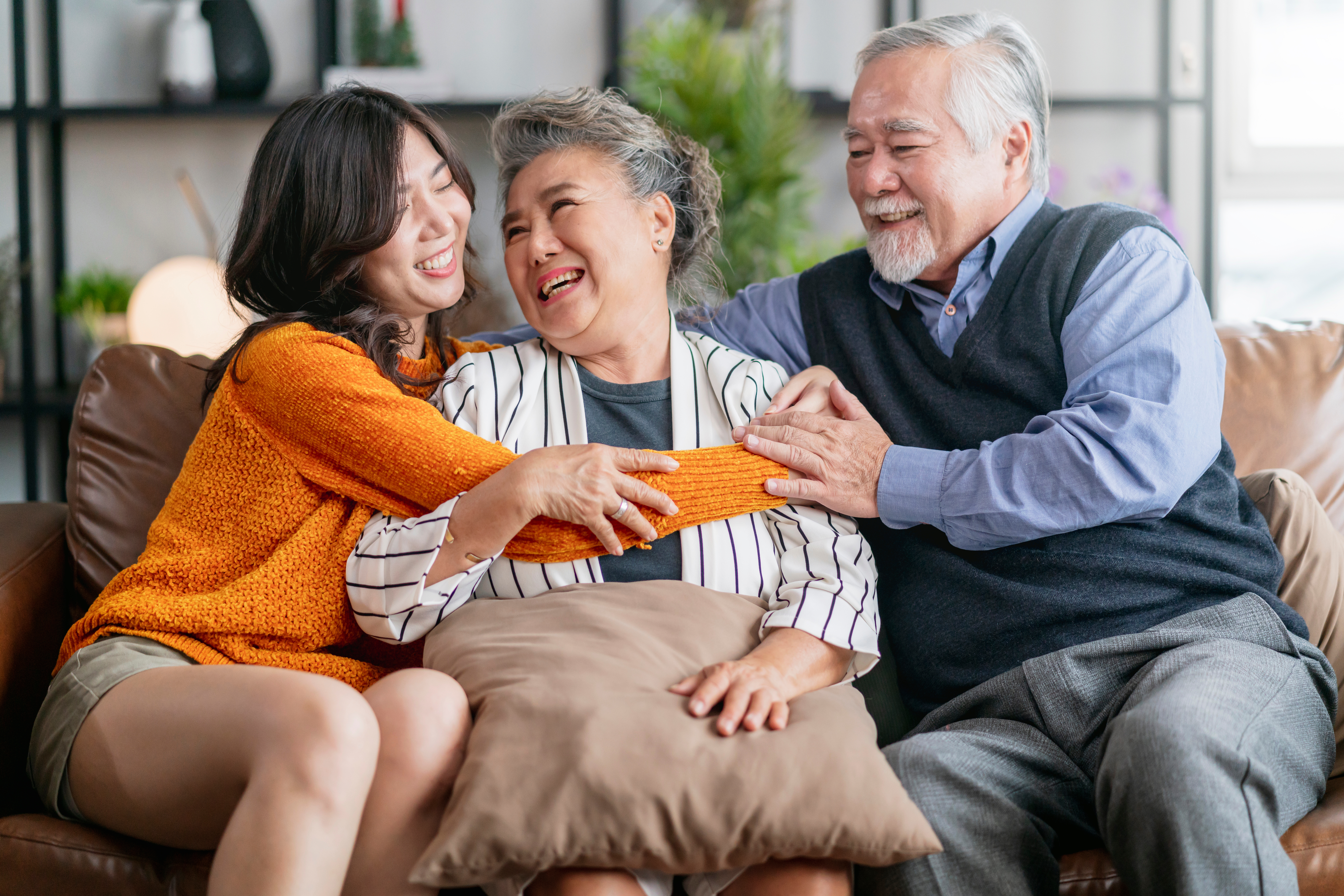 A granddaughter hugging her grandparents.