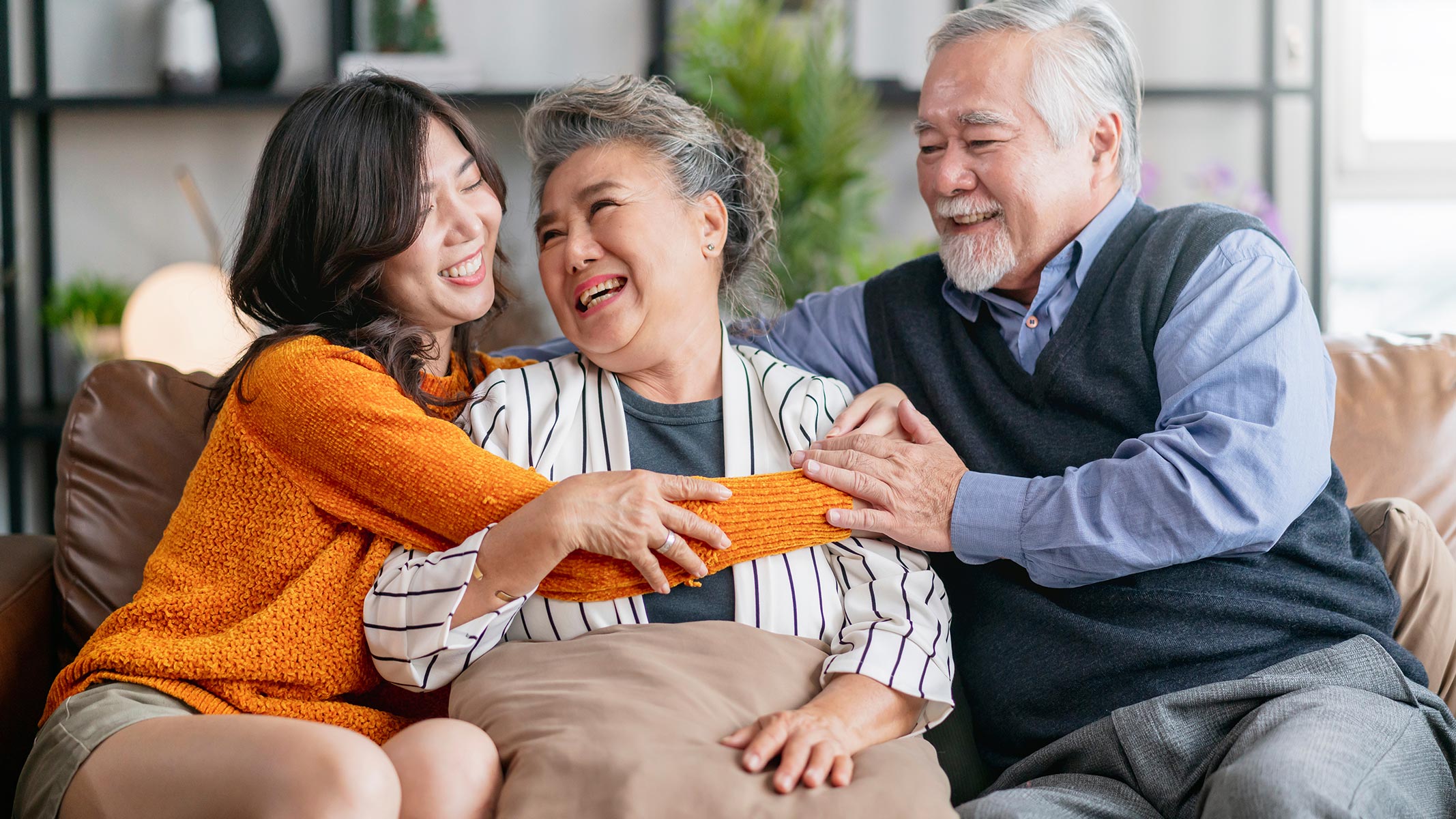 A granddaughter hugging her grandparents.
