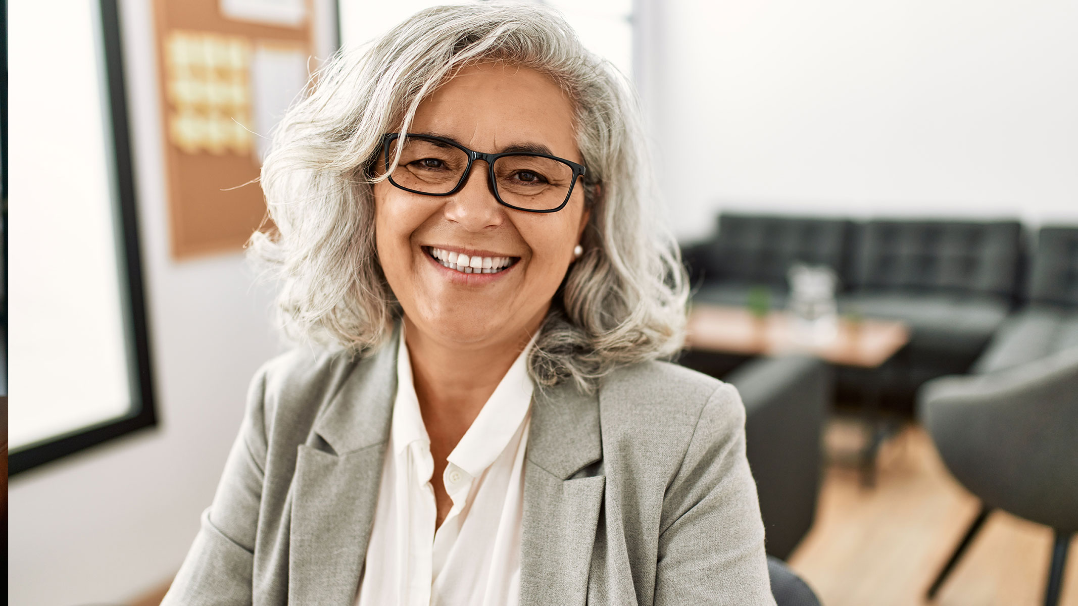 Woman with gray hair smiling at camera